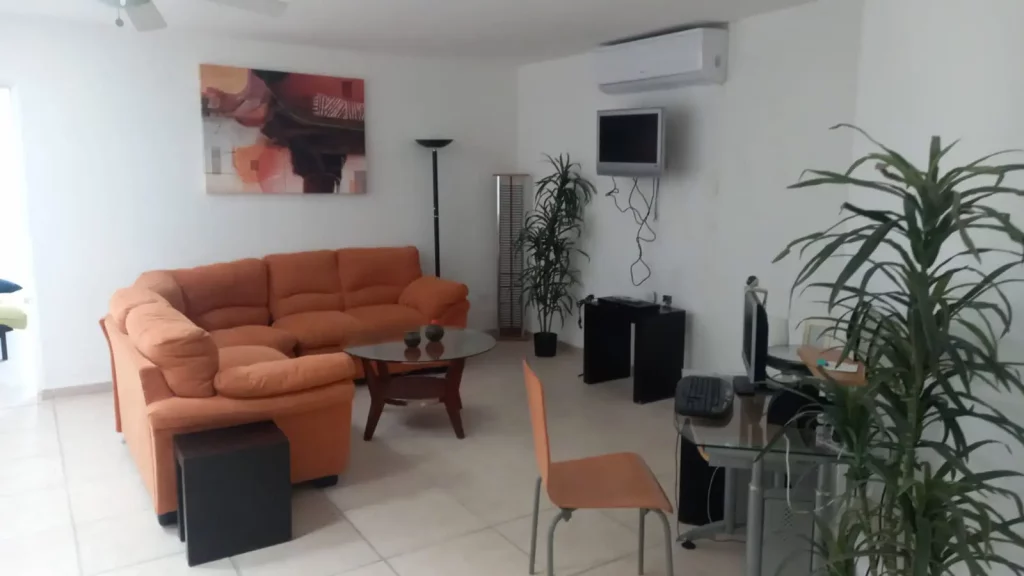 Área de descanso con sillones acolchonados y televisión en casa en venta en Bahía de Kino