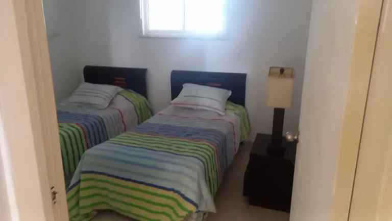 Secondary bedroom with two beds in a coastal home
